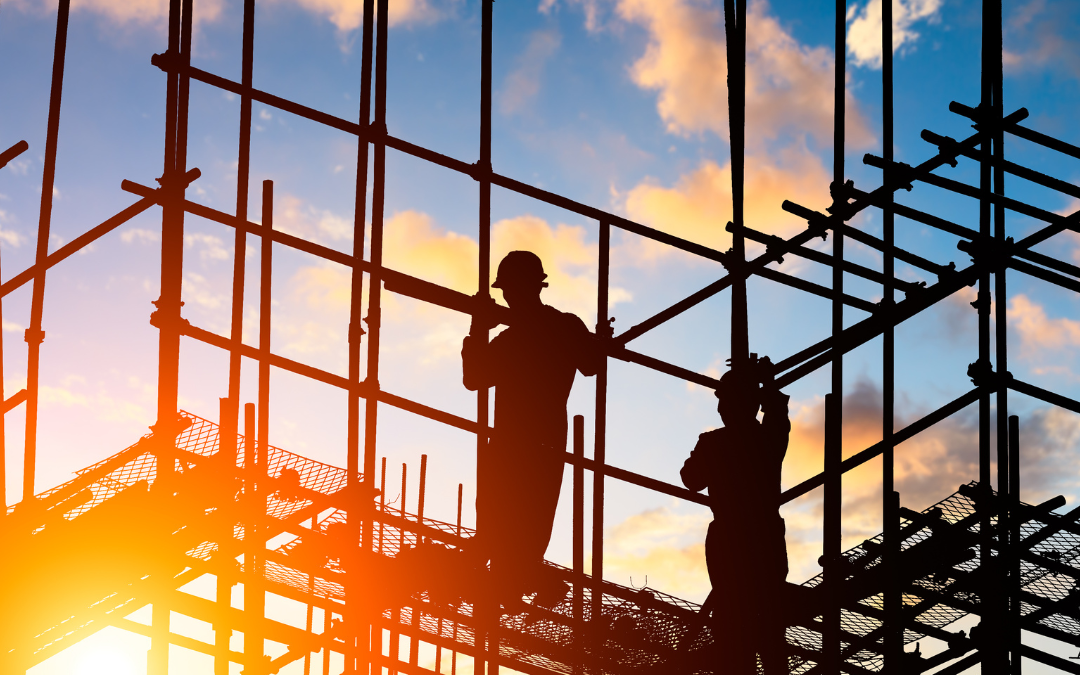 Scaffolding and construction workers with the sunset sky as a backdrop.