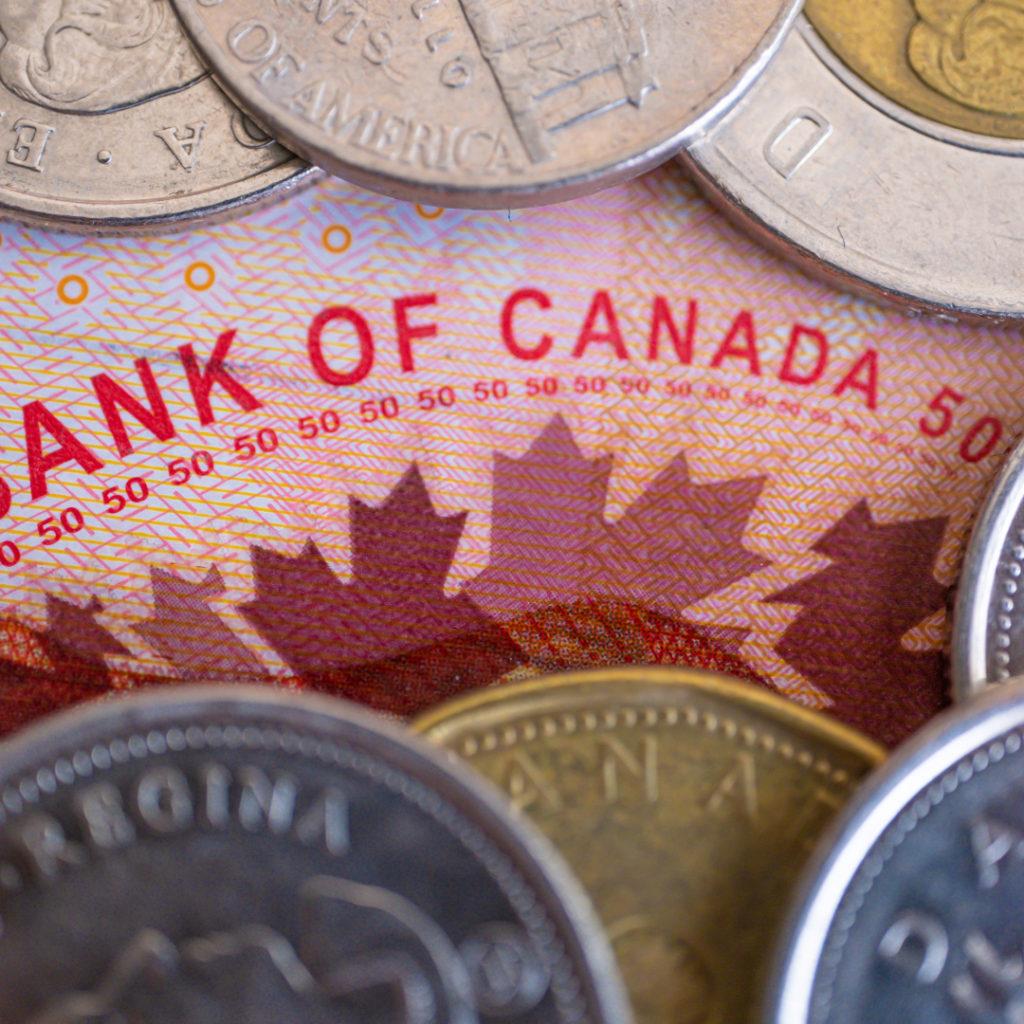 A Bank of Canada fifty dollar bill, the words "Bank of Canada" surrounded by Canadian and some American coins
