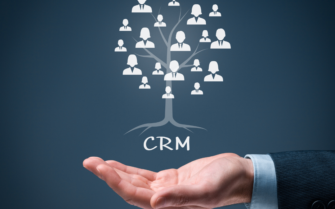 A businessman's hand holding the word CRM above his palm, and growing upward from CRM is a tree connecting a dozen tiny people